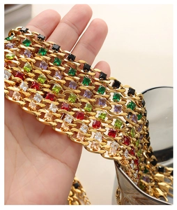 Dettaglio di collana dorata multistrato con zirconi colorati incastonati a griffe