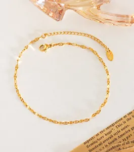 Detailed macro of a 18K gold-plated titanium steel ankle bracelet with K18 engraved tag