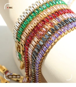 Close-up of elegant gold plated tennis bracelets featuring colorful emerald cut zircons