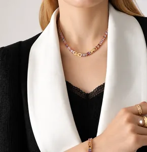 Detailed view of elegant gold jewelry set with colorful zircon on a stylish model