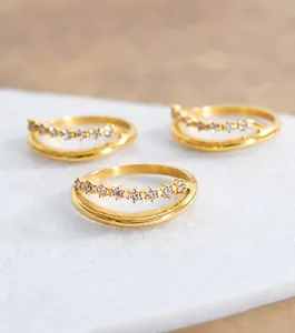 Vista macro de anillos de doble capa bañados en oro de 18k con circonitas brillantes