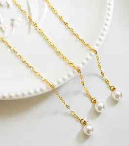 Detail van de gouden ketting met witte parels op een bord voor modieuze sieraden