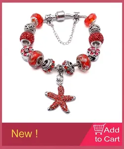 Detailed view of red starfish pendant and textured glass beads on silver chain bracelet