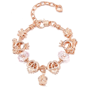 Close-up of rose gold charm bracelet with pink crystals and heart crown pendants