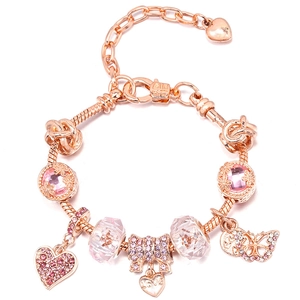 Macro shot of rose gold charm bracelet with pink crystals and heart pendant detail