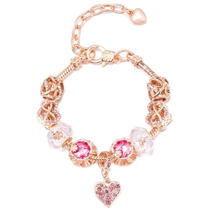 Macro shot of rose gold charm bracelet with pink heart pendant and crystal beads