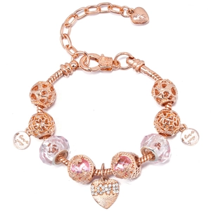 Macro detail of rose gold charm bracelet with pink floral beads and love heart pendant