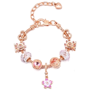 Close-up of rose gold charm bracelet featuring pink cherry blossoms and Ferris wheel charms