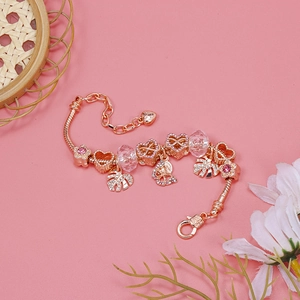Detailed close-up of rose gold charm bracelet with crystal beads and heart pendants