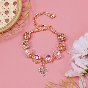 Detail of rose gold snake chain bracelet with pink crystal charms and heart pendant