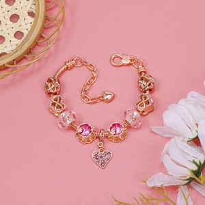 Macro detail of rose gold snake chain with pink enamel flower beads and heart pendant
