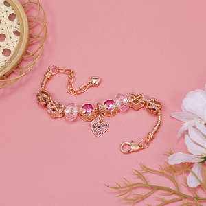 Close-up of rose gold beaded bracelet with pink crystal charms and heart pendants