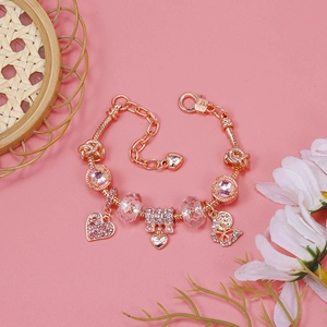 Close-up of rose gold charm bracelet with pink crystal beads and love heart pendants