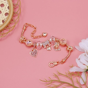 Close-up of rose gold snake chain bracelet with pink crystal beads and love heart charms