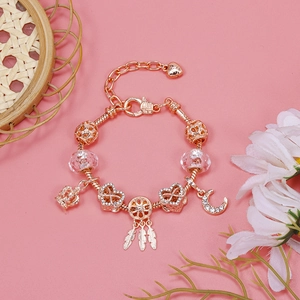 Macro view of rose gold charm bracelet with moon crown heart charms and glass beads