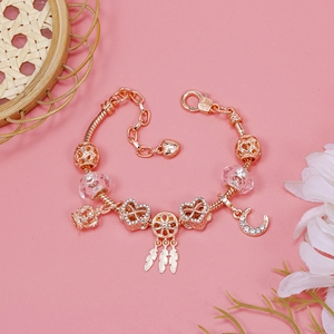 Detailed view of rose gold charm bracelet with crown, heart, and crystal pendants