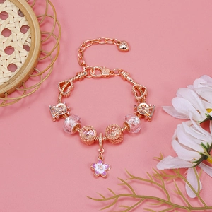 Close-up of rose gold charm bracelet with pink crystals and enamel flower pendant
