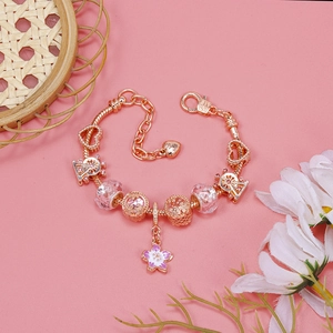 Detailed macro of rose gold cherry blossom charm bracelet with glass beads and snake chain