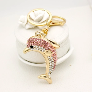 Luxury dolphin keychain with pink rhinestones and gold metal lobster clasp on white decor