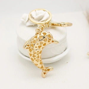 Luxurious gold dolphin keychain with hollow heart patterns and metallic spring clasp