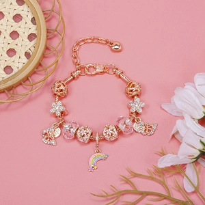 Macro shot of rose gold charm bracelet with rainbow stars and butterfly flower pendants