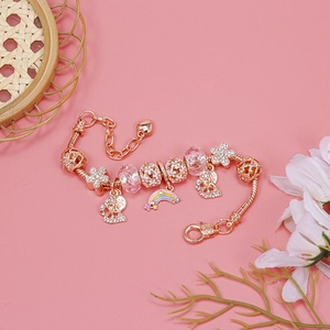 Detailed macro of rose gold bracelet featuring rainbow and flower charms with heart clasp