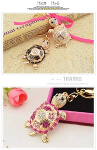 Close-up of golden turtle keychains with crystal rhinestones in pink and black colors