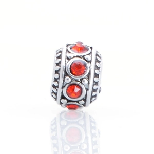 Macro view of vintage silver alloy charm bead with red crystal inlay for DIY bracelets