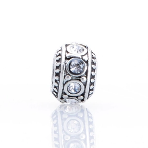 Macro shot of silver plated charm bead with sparkling cubic zirconia and beaded edges