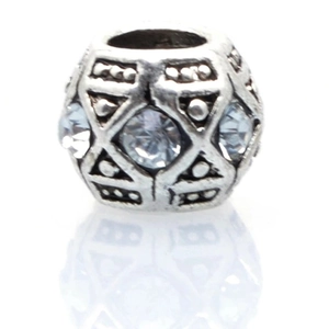 Macro view of vintage silver alloy bead with light blue stone and geometric relief