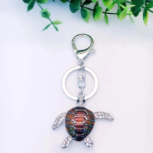 Sparkling sea turtle keychain with rhinestones and brown enamel in silver alloy finish
