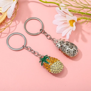 Macro view of crystal pineapple keychain charms with yellow rhinestones and silver details