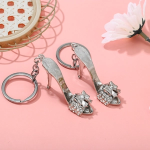 Detailed view of silver stiletto shoe keychains with sparkling crystal bow accents
