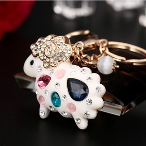 Porte-clés mouton blanc scintillant avec pierre bleue en goutte et accents or rose