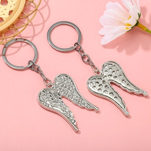 Detailed view of silver angel wing keychains with sparkling rhinestones and heart hollow back