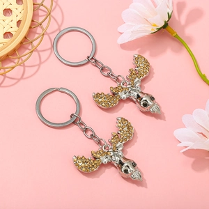 Close-up of reindeer keychain with amber rhinestones on a pink background