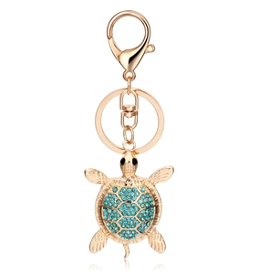 Macro detail of turtle keychain with turquoise shell and sparkling gold alloy plating