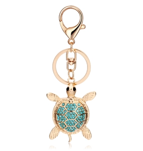 Detailed close-up of a turtle keychain featuring blue rhinestones and gold plating