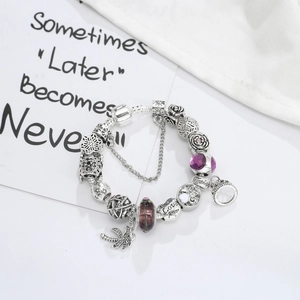 Bracciale con perline di cristallo viola e ciondoli a forma di corona e palma