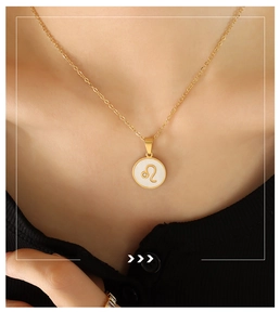 Detailed close-up of a Leo zodiac white shell pendant necklace on golden steel chain