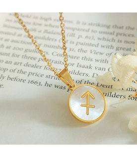Macro shot of Sagittarius zodiac pendant with white mother of pearl in gold plating