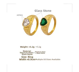 Detailed close-up of French heart rings with white and green glass stones in gold finish