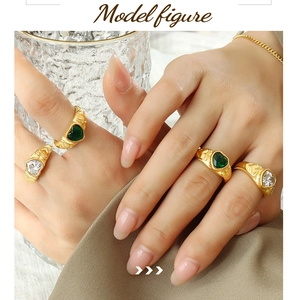 Detail showing stacked French style heart glass stone rings in gold with embossed textures