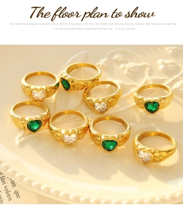Macro detail of heart-shaped green and white stones set in engraved gold band rings