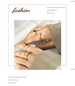 Detail of gold heart rings with green and white gems and vintage relief patterns
