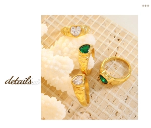 Detailed macro of heart-shaped glass stone rings with ornate golden engraved bands