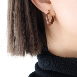 Retro V-shaped gold hoop earrings with brown enamel finish shown on model ear