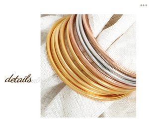 Close-up of minimalist titanium steel stacking bangles in gold rose gold and silver