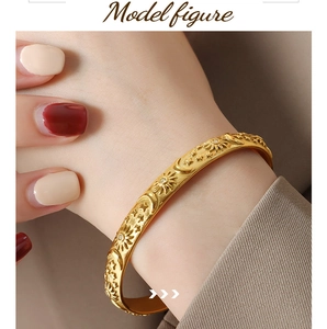 Detail of gold-plated bangle featuring embossed sun and moon patterns with zircon inlay