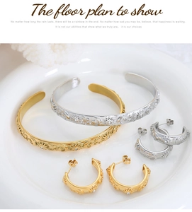 Detail shot of gold and silver sun moon star embossed jewelry sets on ceramic tray